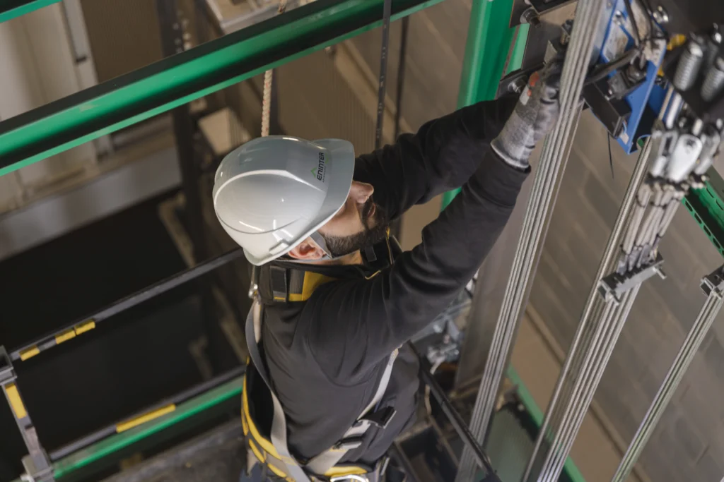 Gemini ha dicho Un tecnico ascensorista qualificato lavora alla manutenzione dei cavi di un ascensore, illustrando come diventare tecnico ascensorista.
